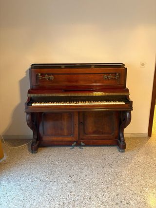 Piano antiguo de madera con candelabro