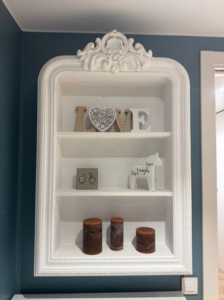 Estantería de madera con marco decorativo
