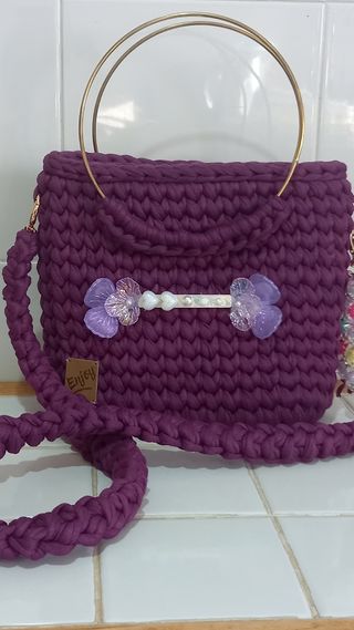 Bolso de mano morado con detalles dorados