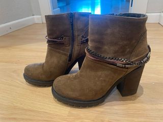 Botines de piel marrones con cadena.
