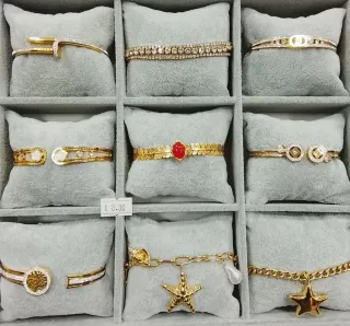 Pulseras doradas con detalles blancos