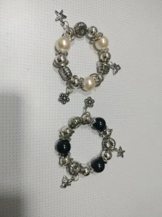 Pulseras plateadas con perlas y dijes