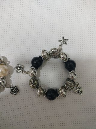 Pulseras plateadas con perlas y dijes