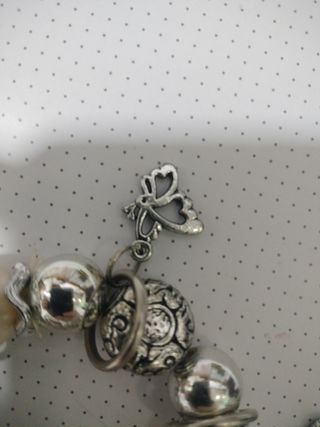 Pulseras plateadas con perlas y dijes