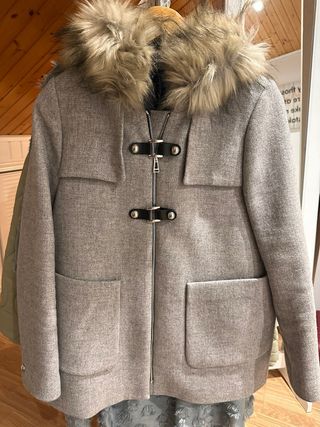 Elegante abrigo gris con capucha y pelo