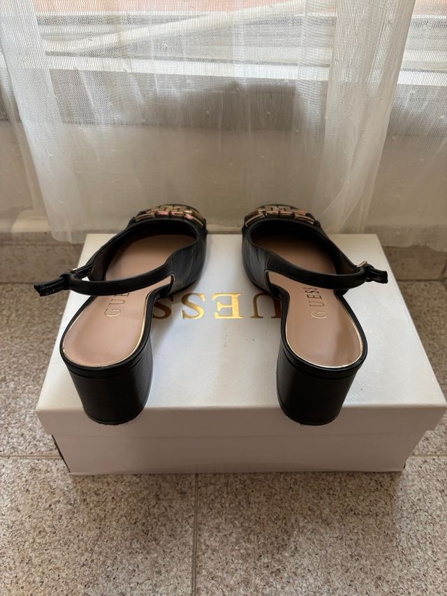 Zapatos tacón Guess negros con detalle dorado. 