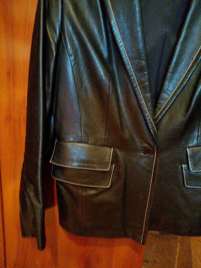 Chaqueta de piel negra con ribeteado blanco.