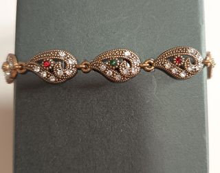 Bracciale color oro con pietre rosse e verdi