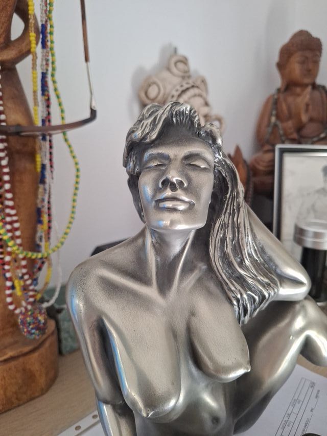 Escultura de mujer desnuda plateada