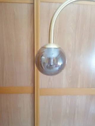 Lámpara de pie dorada con globo de cristal