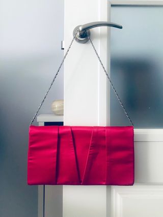 Cartera de mano fucsia con cadena
