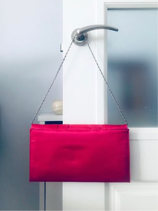 Cartera de mano fucsia con cadena