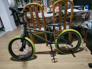 Bicicleta BMX verde con ruedas amarillas