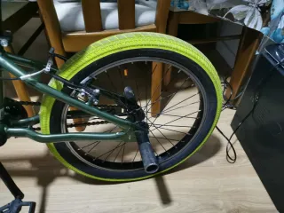 Bicicleta BMX verde con ruedas amarillas