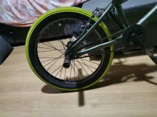Bicicleta BMX verde con ruedas amarillas