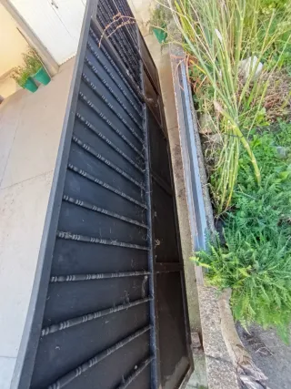 Portón de entrada de hierro , tiene puerta acceso
