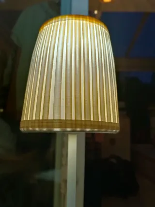 Lámpara de mesa blanca con pantalla beige.