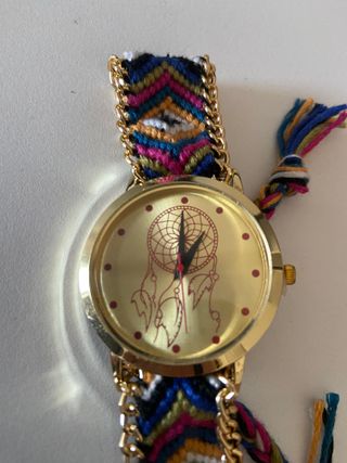 Reloj dorado con pulsera tejida y cadena