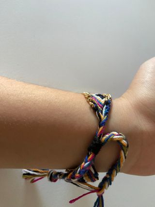 Reloj dorado con pulsera tejida y cadena