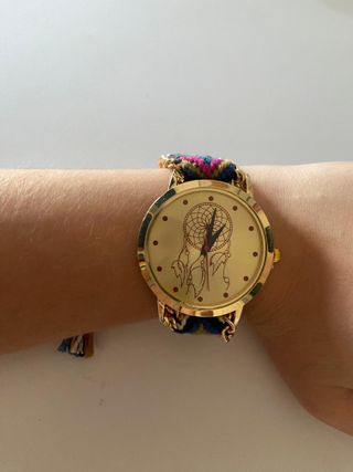 Reloj dorado con pulsera tejida y cadena