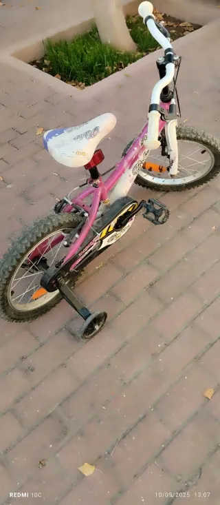Bicicleta infantil rosa con ruedines