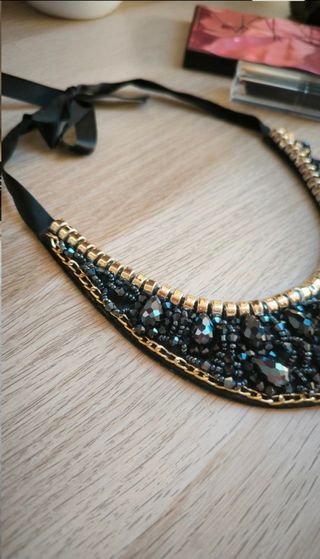 Collar negro con abalorios y lazo.