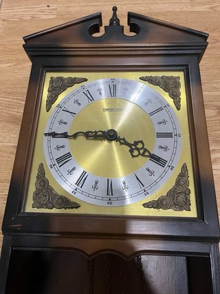 Reloj de pared madera y dorado.