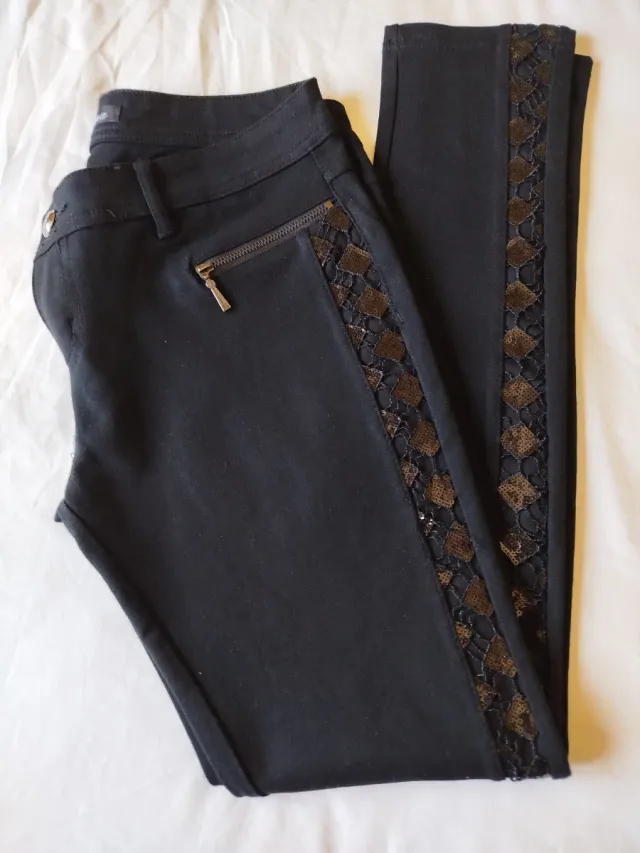Pantalón negro ajustado con detalles plateados.