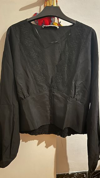 Blusa negra escote en V con encaje. 