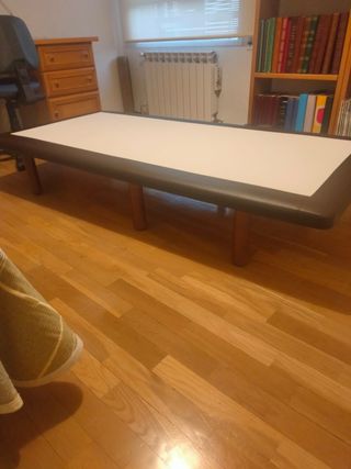 Base imbottita in pelle, legno e tessuto.