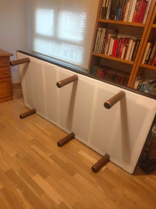 Base imbottita in pelle, legno e tessuto.