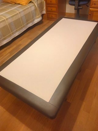 Base imbottita in pelle, legno e tessuto.