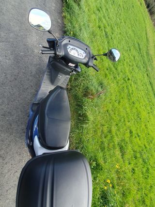 Moto azul con baúl está perfecta