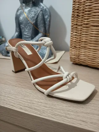 Sandalias blancas de tiras con nudo.