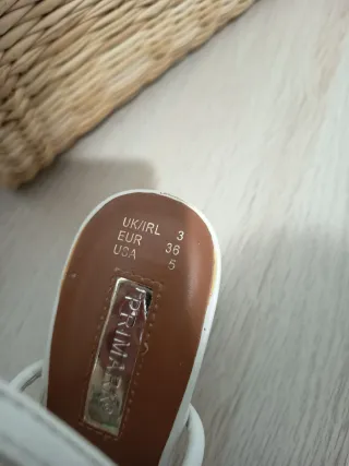 Sandalias blancas de tiras con nudo.