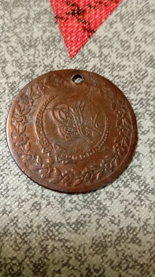 Moneda antigua de cobre con flores