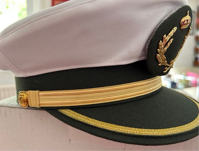 Gorra estilo militar verde con detalles dorados.