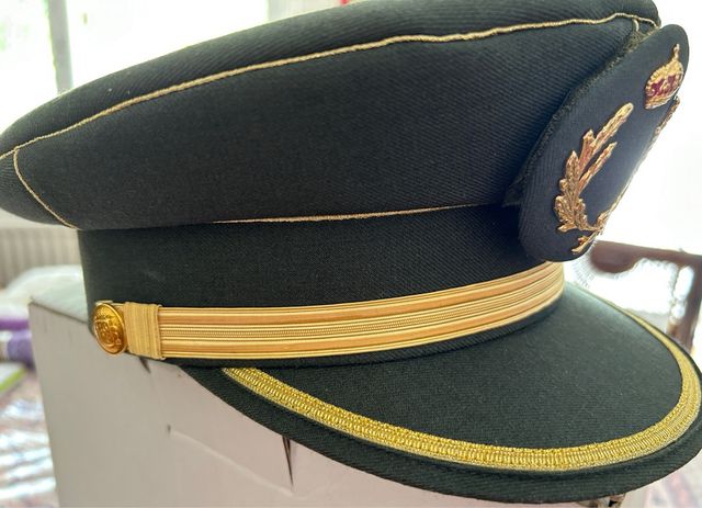 Gorra estilo militar verde con detalles dorados.