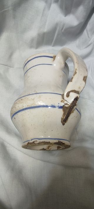 Jarra antigua esmaltada con rayas azules y lañas