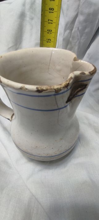 Jarra antigua esmaltada con rayas azules y lañas