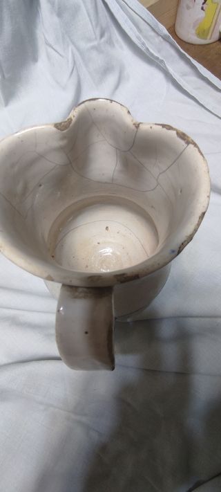 Jarra antigua esmaltada con rayas azules y lañas