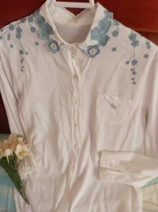 Camisa blanca bordada y pantalón azul