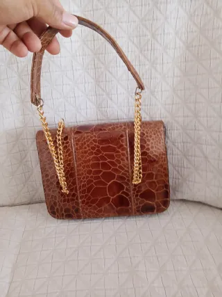 Bolso de piel marrón con cadena dorada