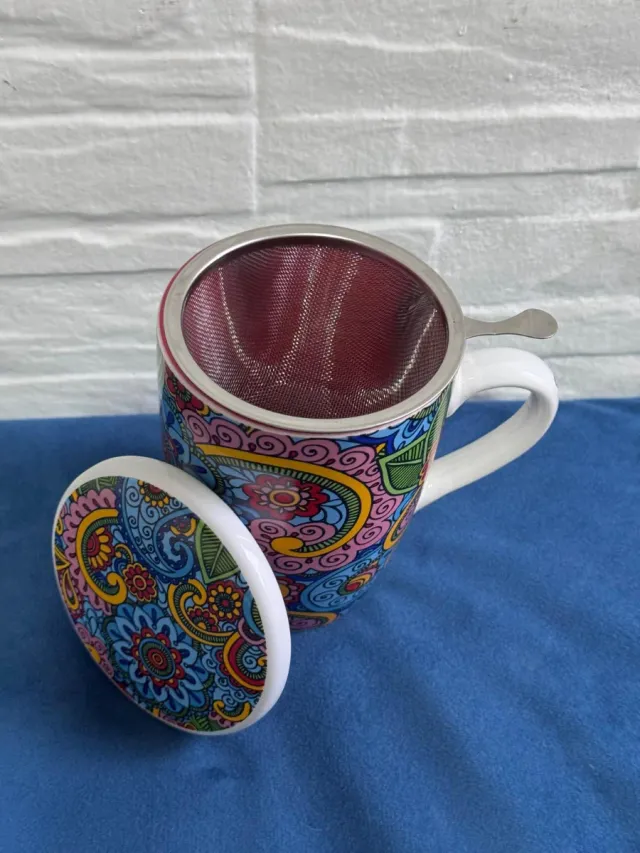 Taza de té con filtro y diseño colorido