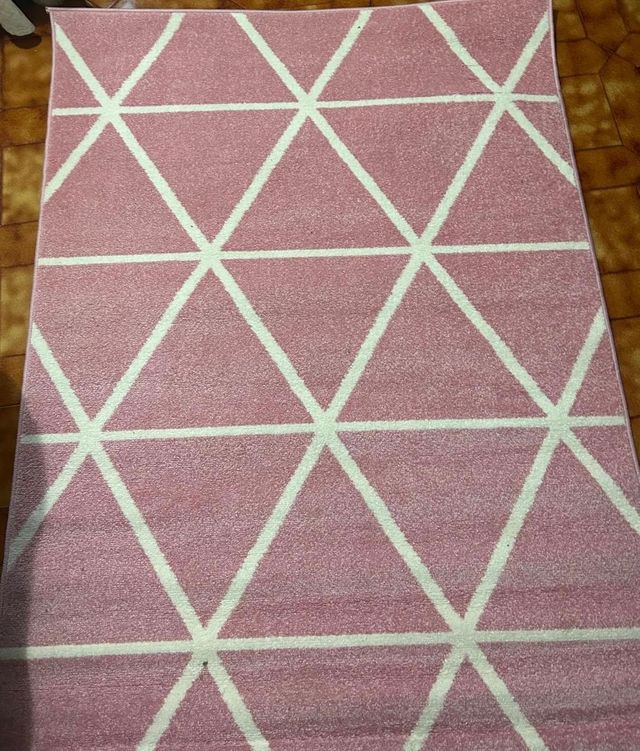 Alfombra geométrica rosa y blanca