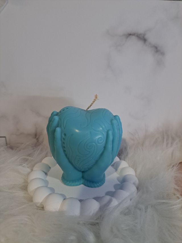 Candela a forma di cuore con mani