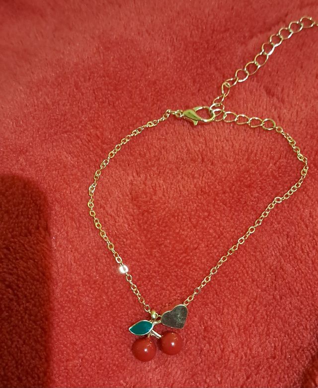 Pulsera dorada con cerezas y corazón