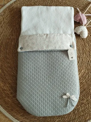 Saco de bebé gris con etiqueta