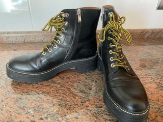 botas negras cordones amarillos
