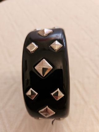 Pulsera negra con tachuelas plateadas.